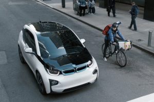 BMW i3 electric vehicle with cyclist